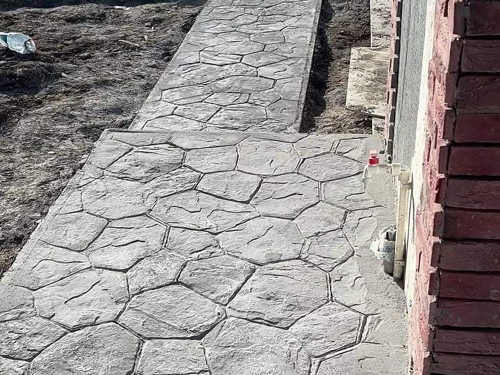 Bina kenarında taş desenli baskı beton yürüyüş yolu
