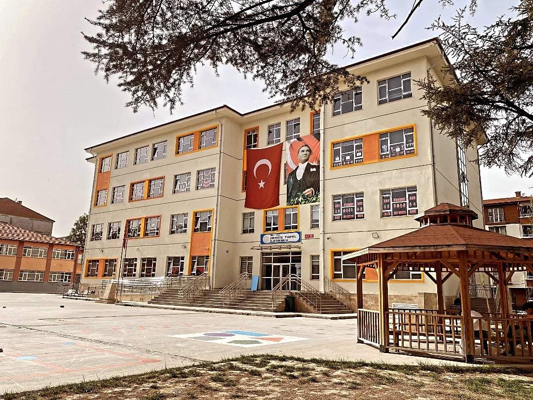 Cengiz Topel İlkokulu cephesi, Türk bayrağı ve Atatürk posteri, önünde ahşap kamelya