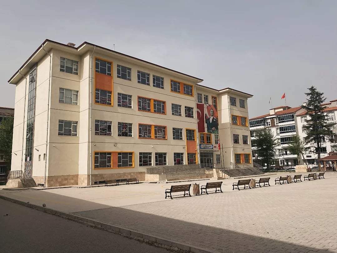 İlkokul binasının yandan görünümü ve banklı bahçe