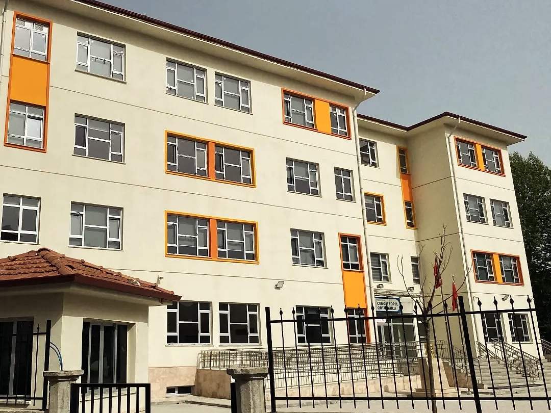 Ortaokul binasının bahçe duvarı ve giriş kapısıyla görünümü