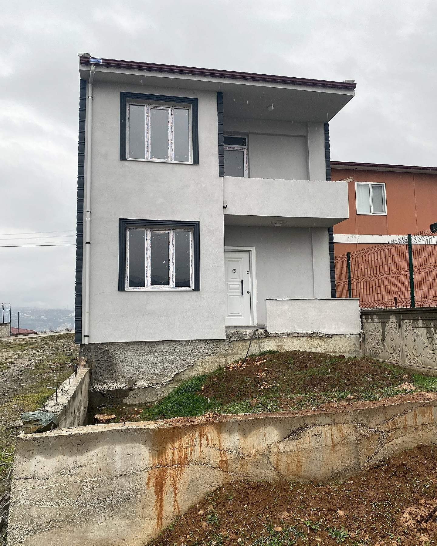 Evin giriş kapısı ve balkonlu yan cephesi