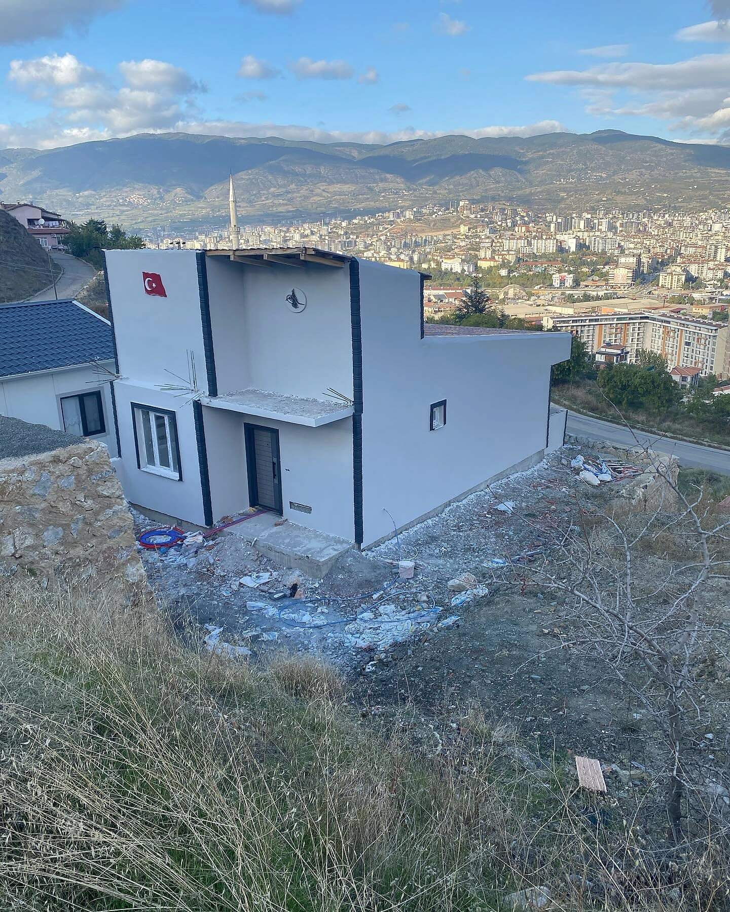 Tokat manzaralı yamaçta beyaz cepheli, lacivert çerçeveli konut