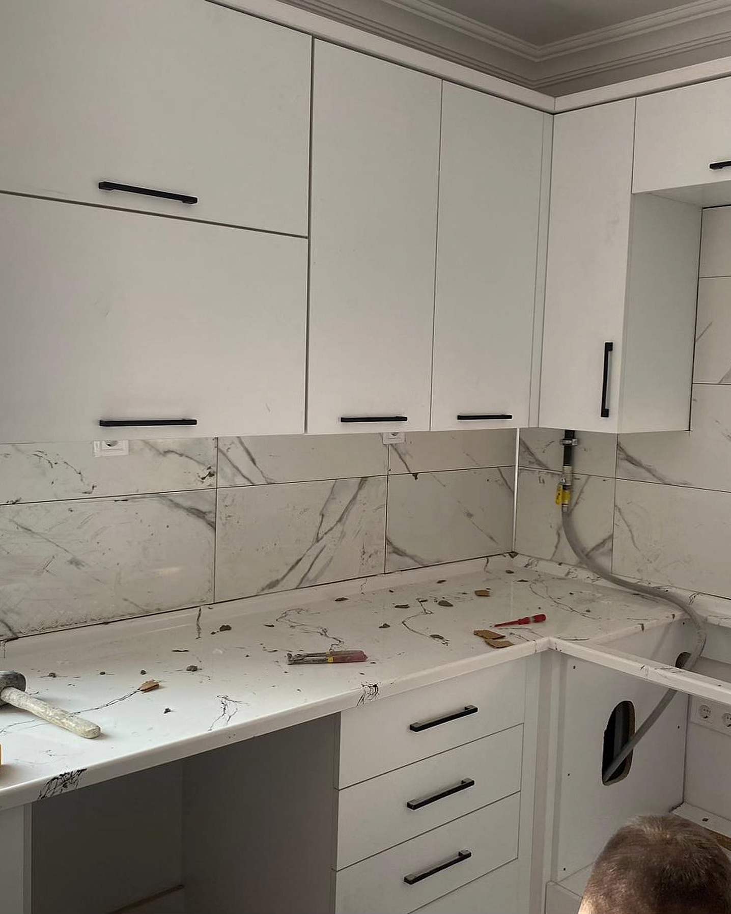Beyaz dolaplı mutfak ve mermer desenli tezgâh