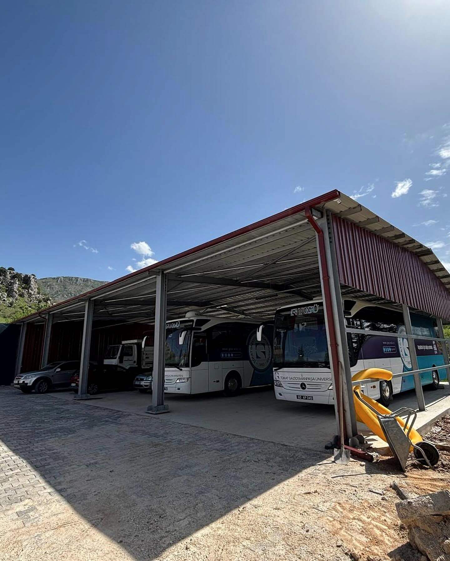 Kırmızı sac kaplı çelik garaj ve içindeki otobüsler