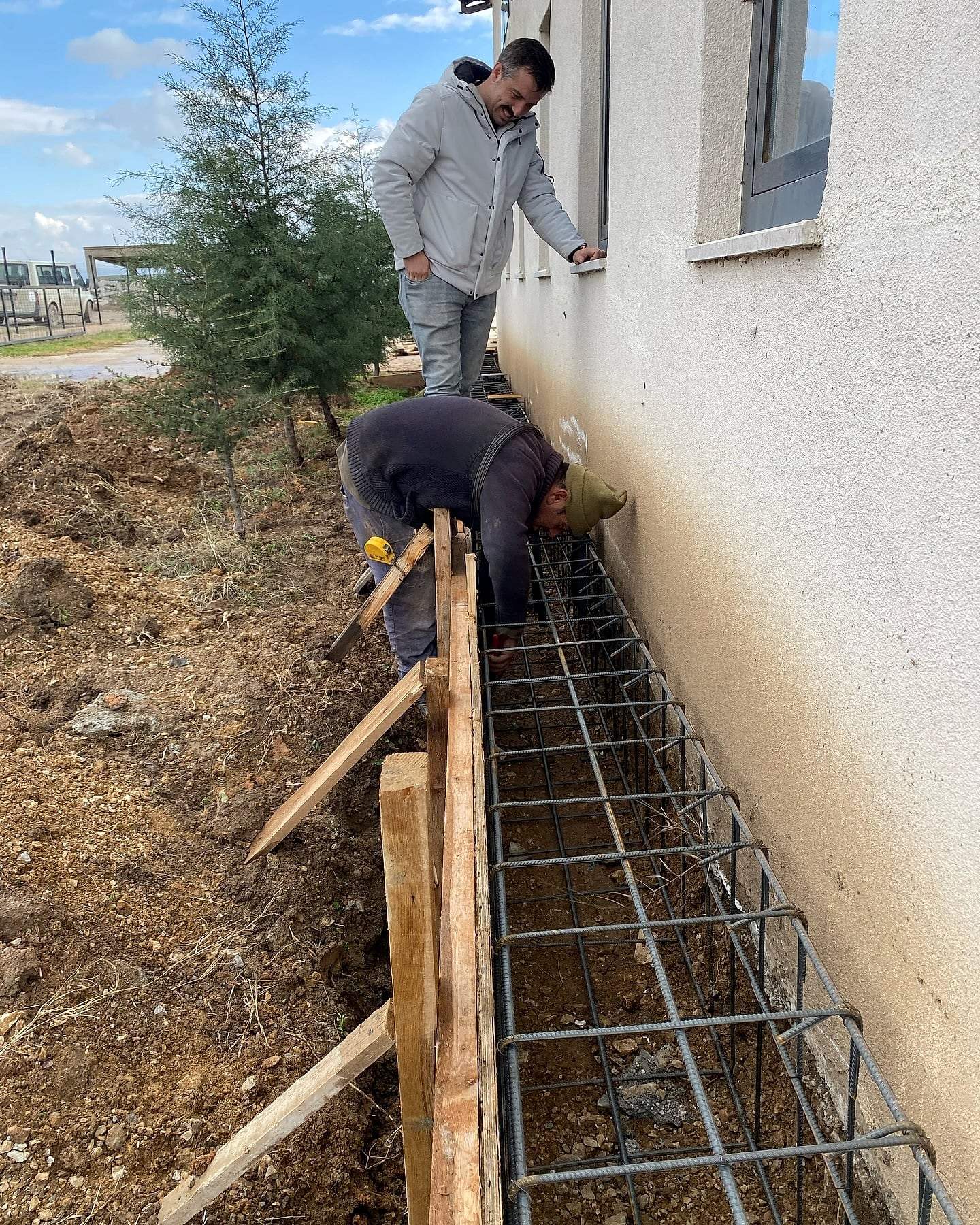 Duvar dibinde donatı bağlayan işçiler