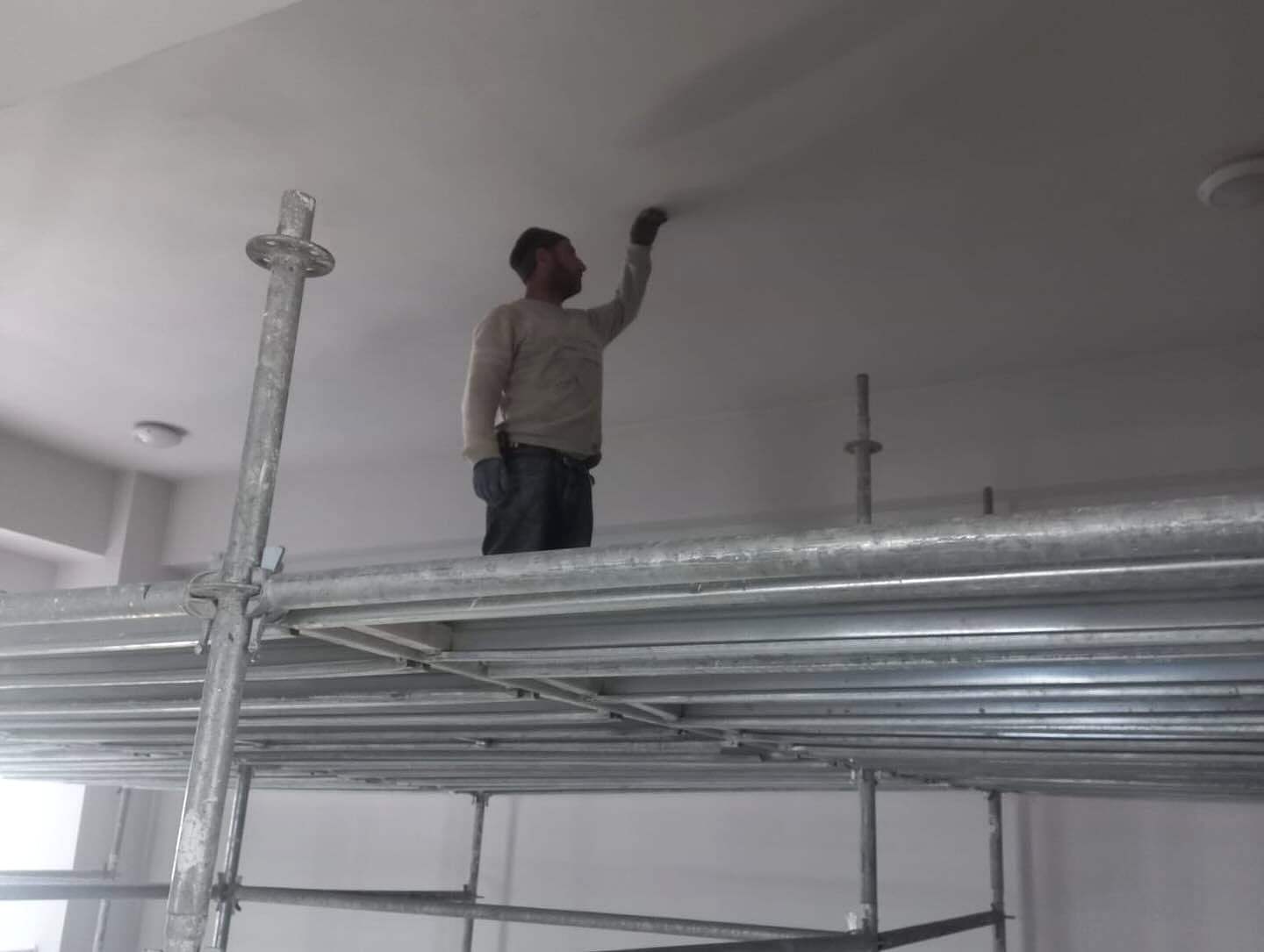 İskele üzerinde tavan boyayan usta